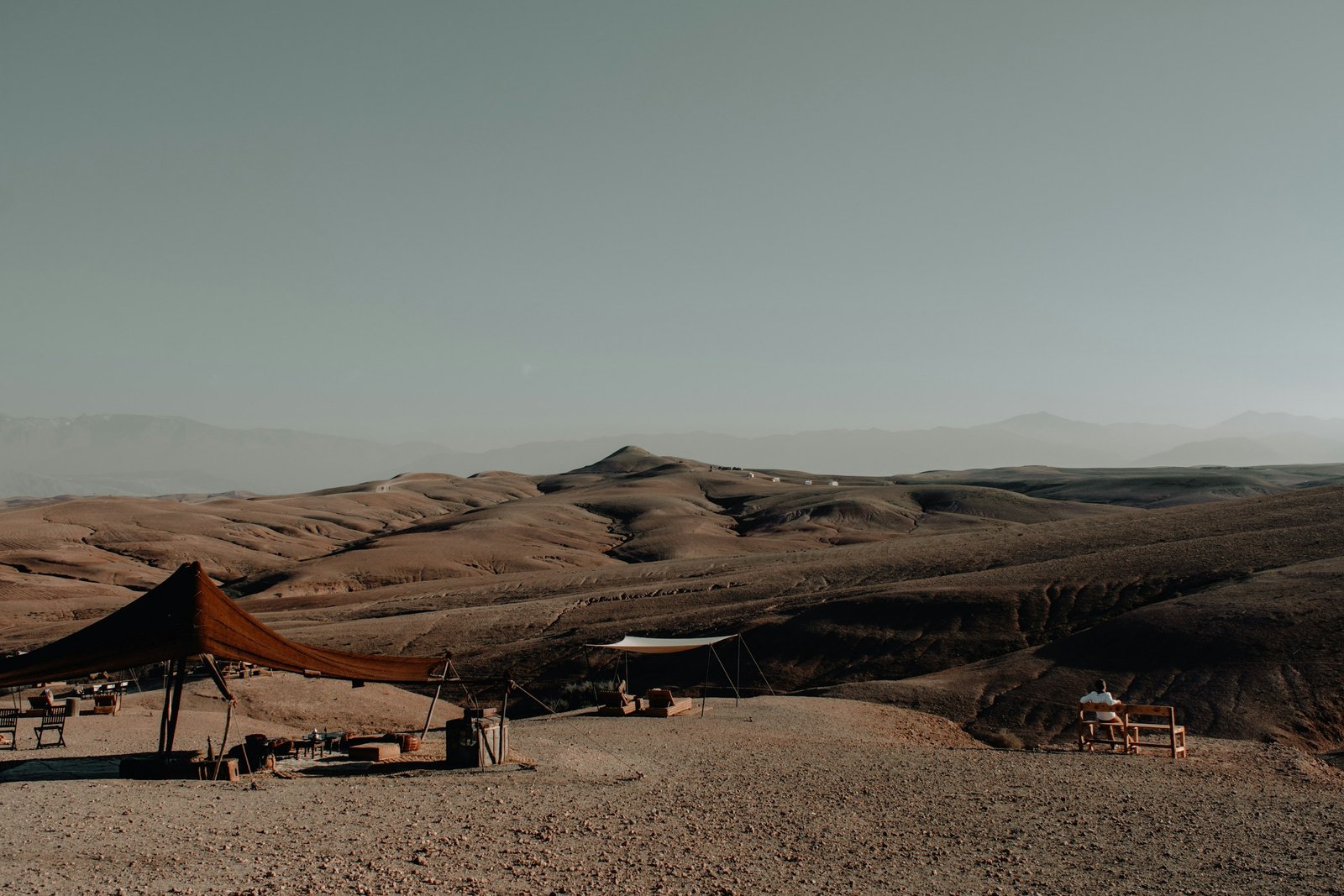 A nomad-style tent camp pitched among the rust-colored dunes of the Agafay Desert near Marrakech