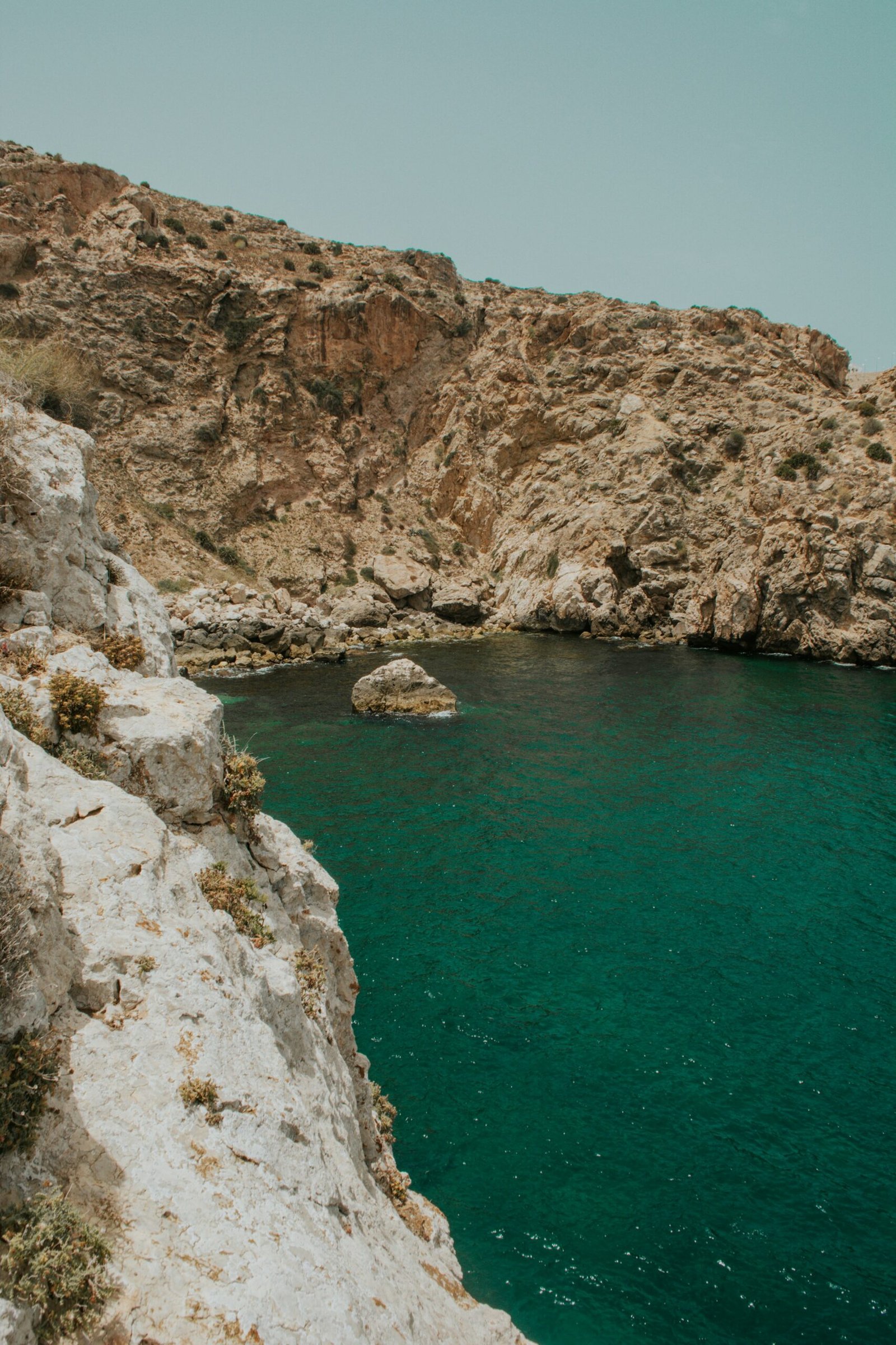 Rocky cliffs meeting turquoise water along the coast near Al Hoceima, Morocco