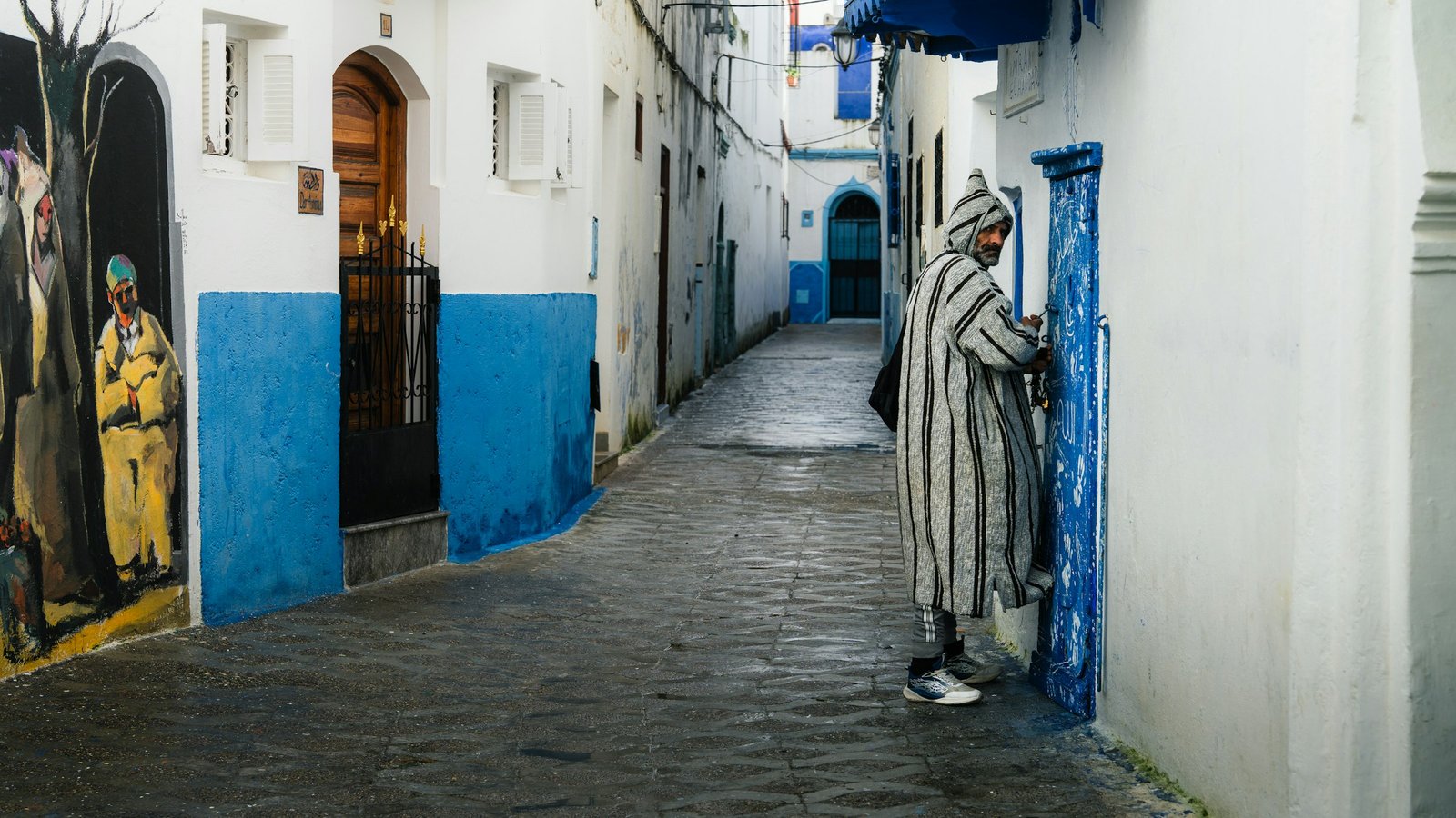 A narrow whitewashed alleyway in the medina of Asilah, Morocco