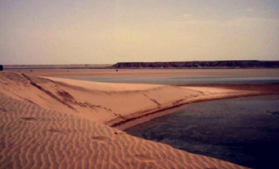 Golden Saharan dunes roll toward the Atlantic near Dakhla