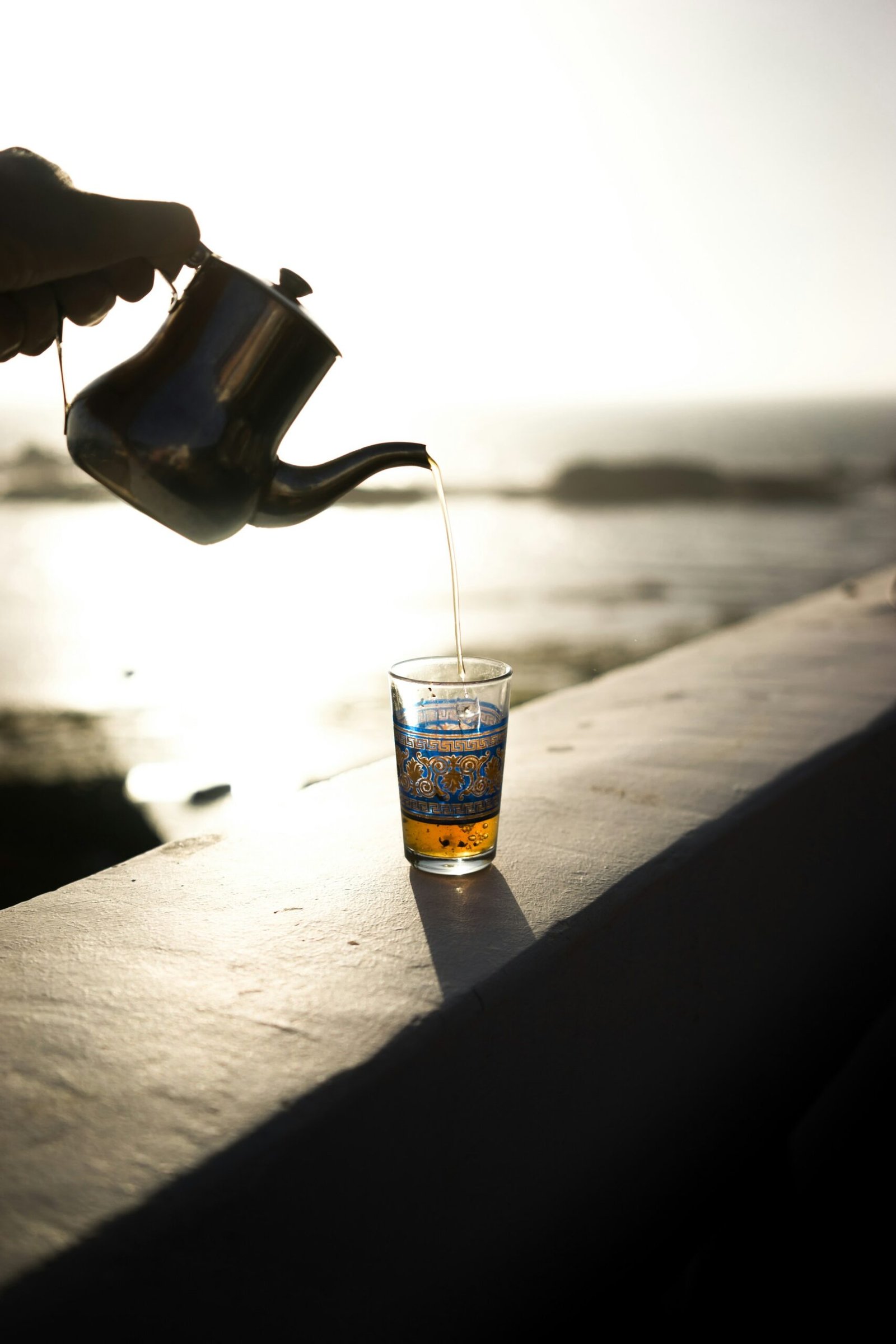 Moroccan mint tea being poured from height into a glass in Essaouira