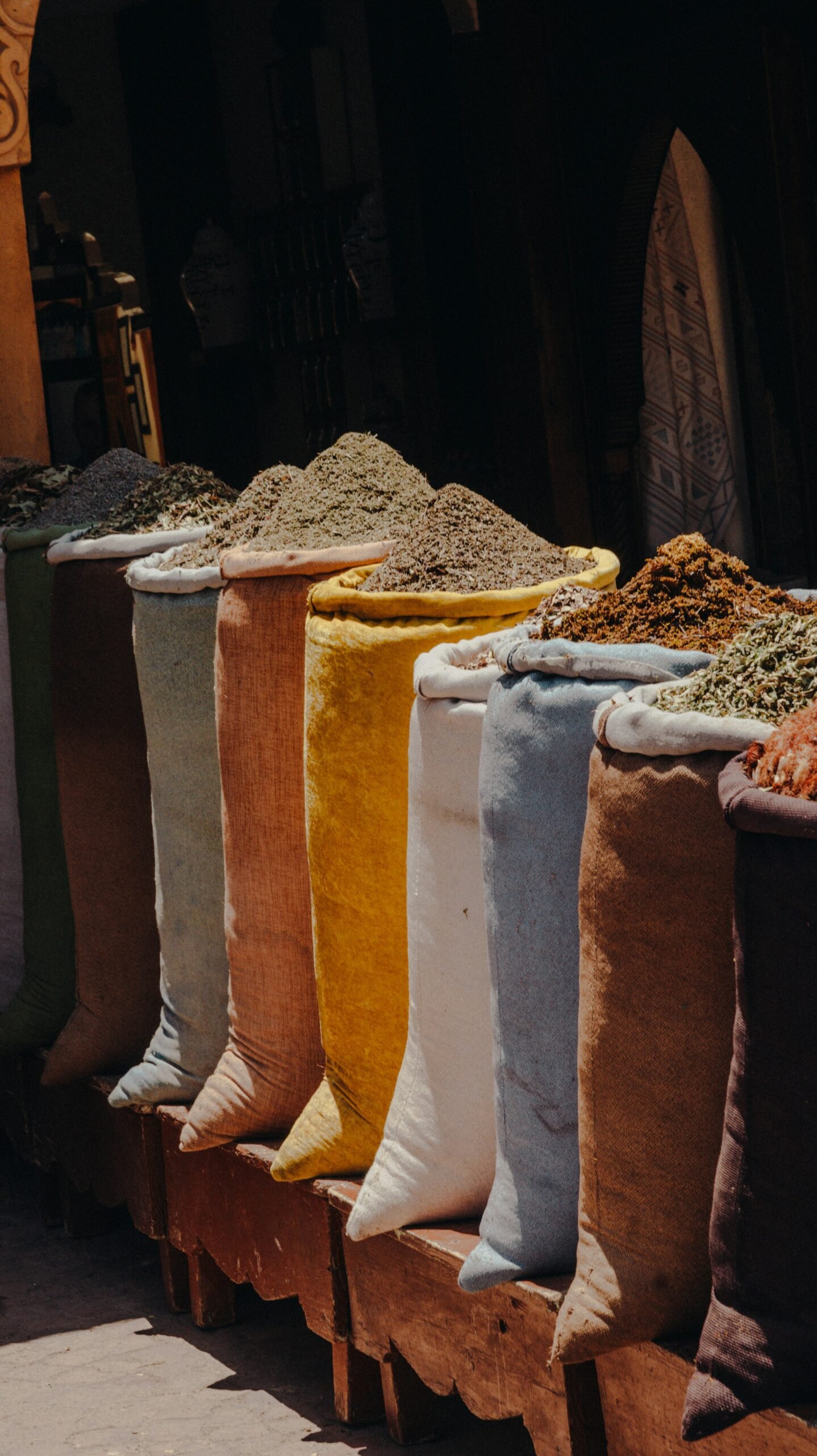 Rows of colorful spice bags on display at a souk market in Marrakech