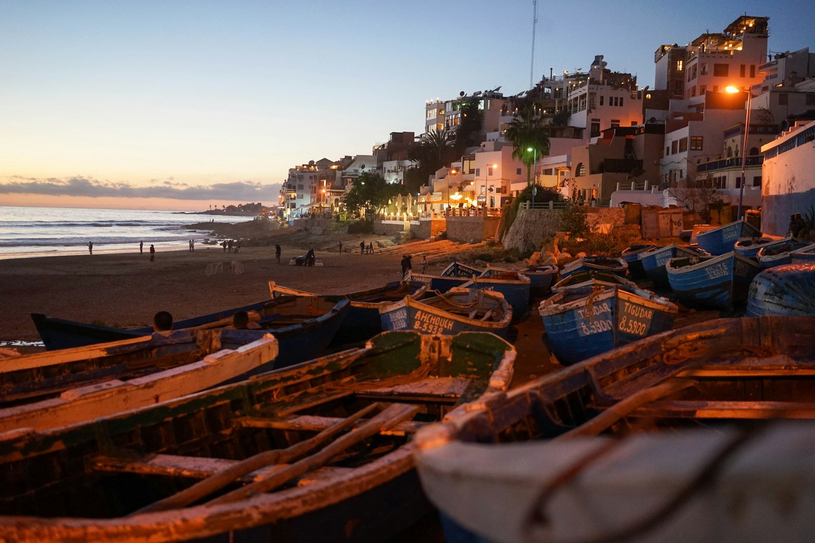 Blue fishing boats glow under the Atlantic sunset