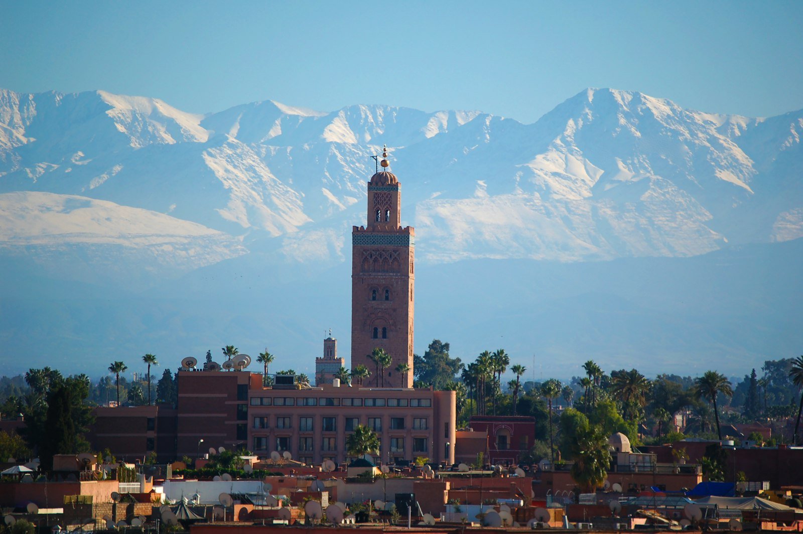 Koutoubia Mosque with snow-capped Atlas Mountains behind it