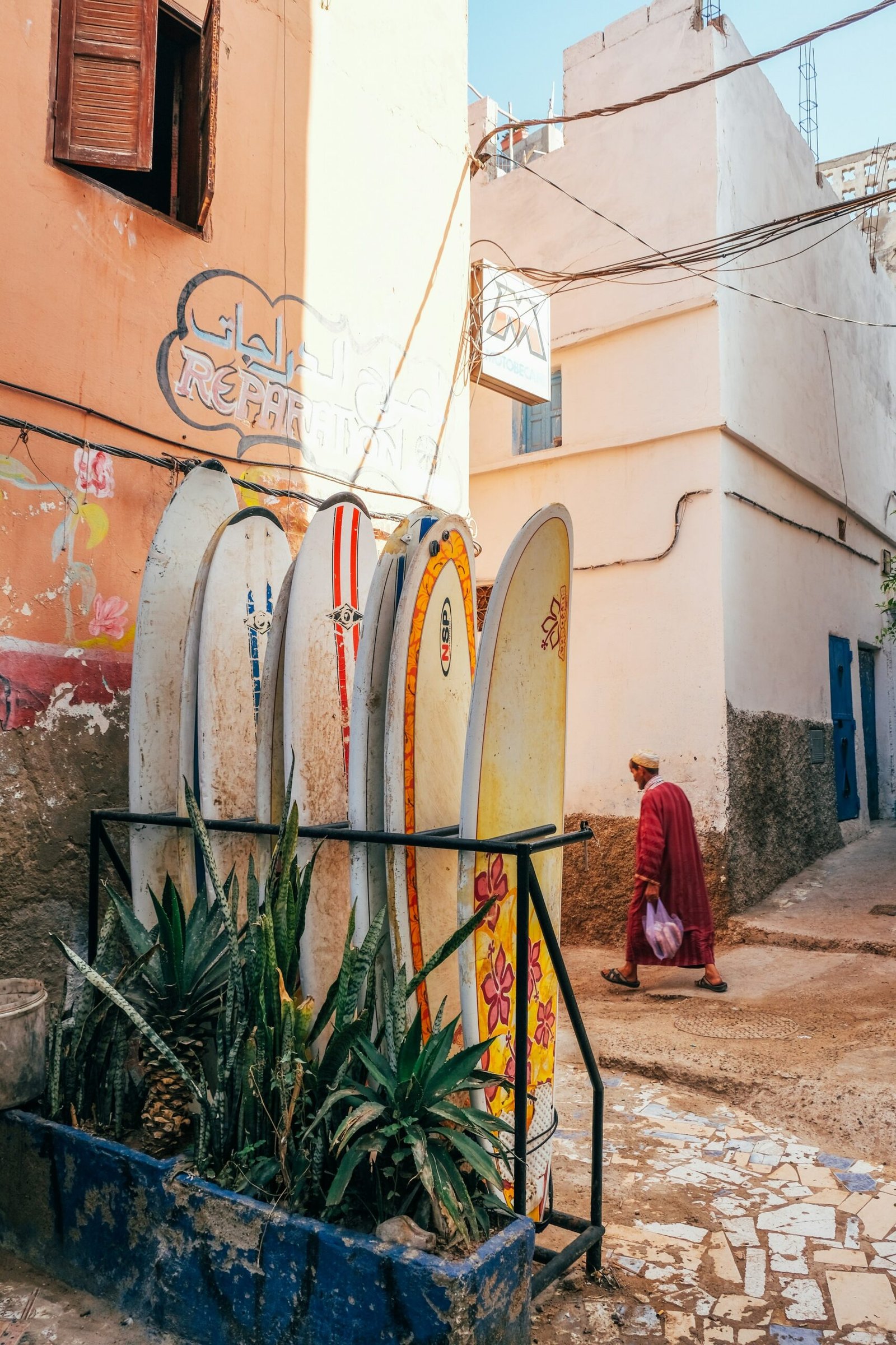 Surfboards leaning against a colorful building in Taghazout village, Morocco