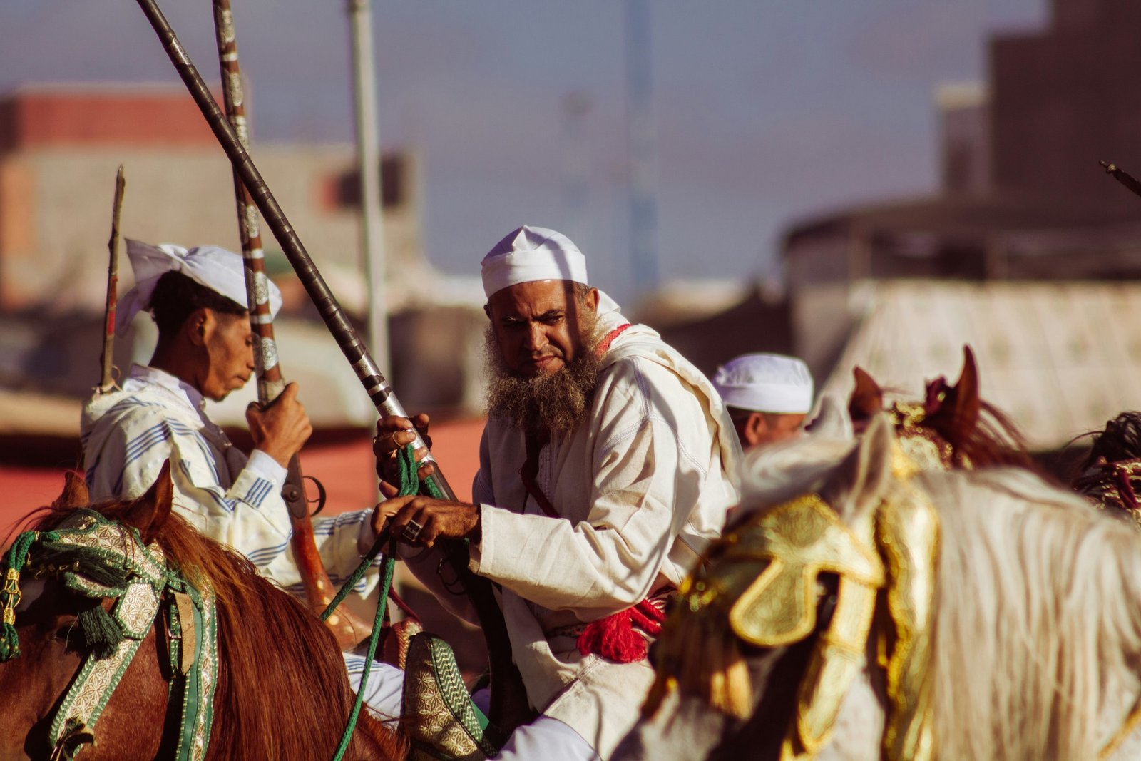Moroccan horsemen in traditional dress riding together during a Tbourida fantasia performance