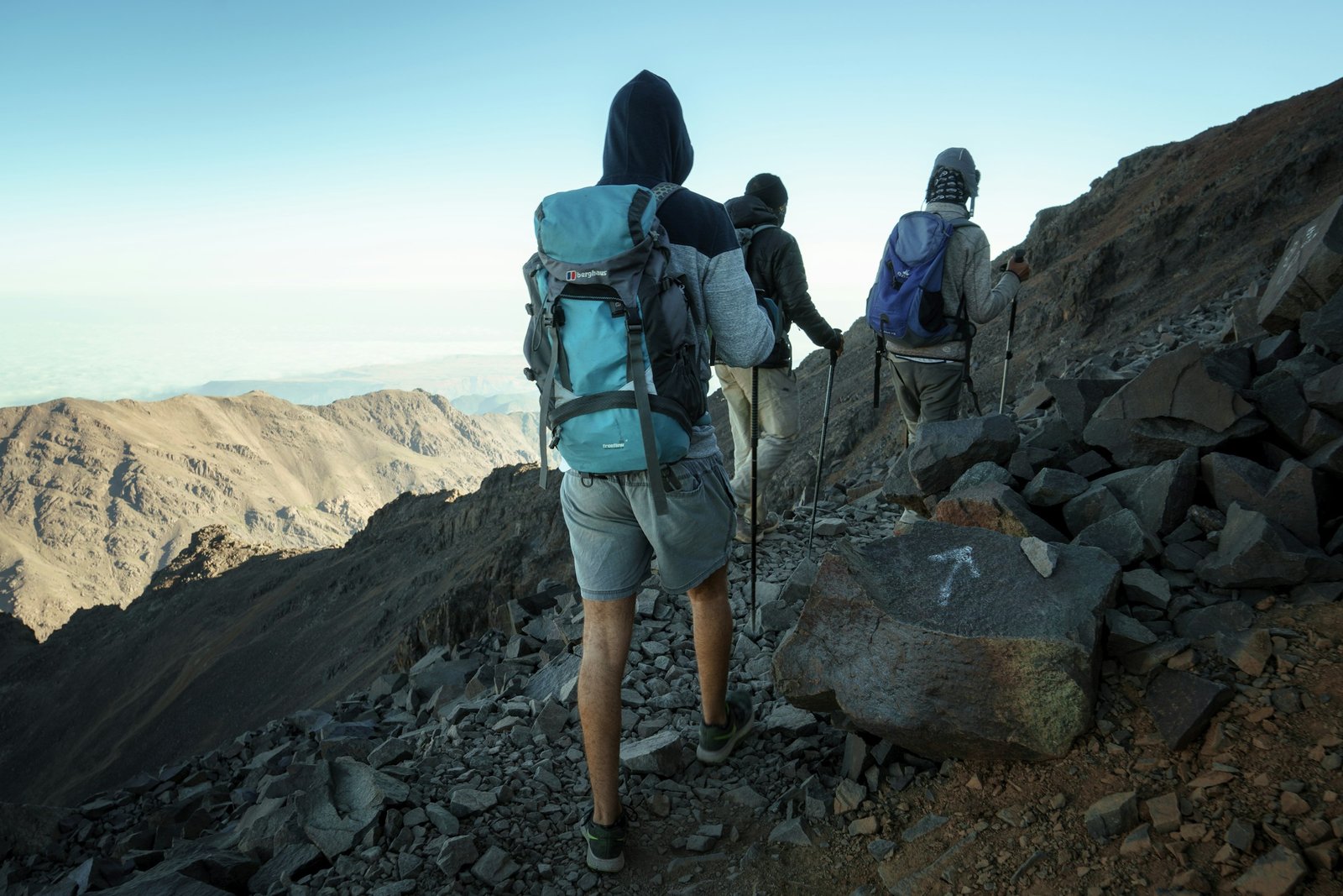 A line of trekkers climbing a rocky ridge on Mount Toubkal in the High Atlas Mountains, Morocco